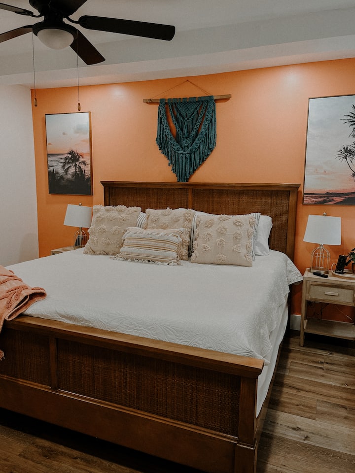 Main level king room. Private access to back patio from this room. Located right next to main level bathroom. This room has a large closet, Extra soft memory foam mattress, a charging hub, lamps and a Smart TV. 