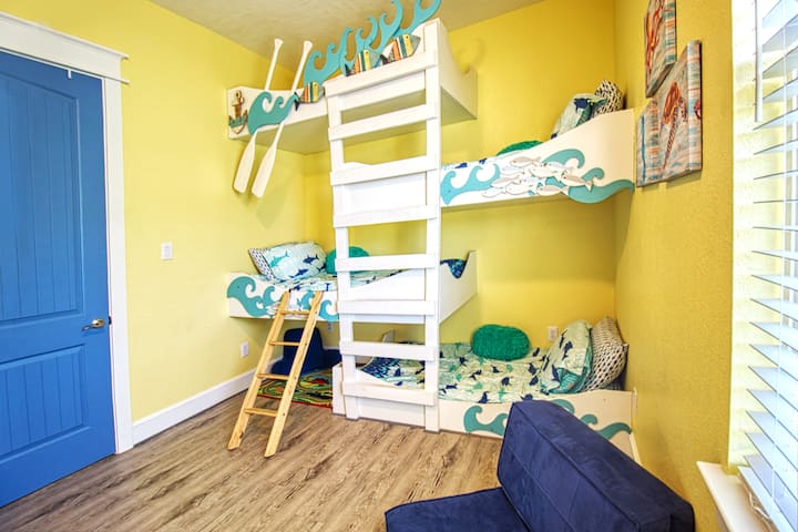 This room has 3 twin-size beds and a TV