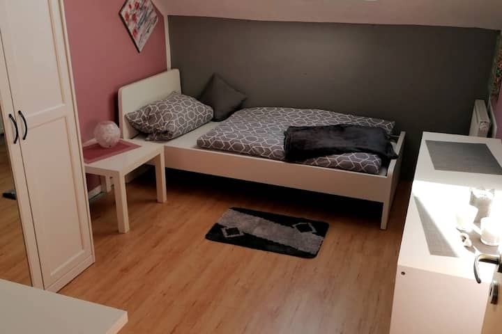 Druga mala spavaća soba s krevetom za jednu osobu, privatnim garderoberom s vješalicama i radnim stolom za slikanje i rukotvorine.