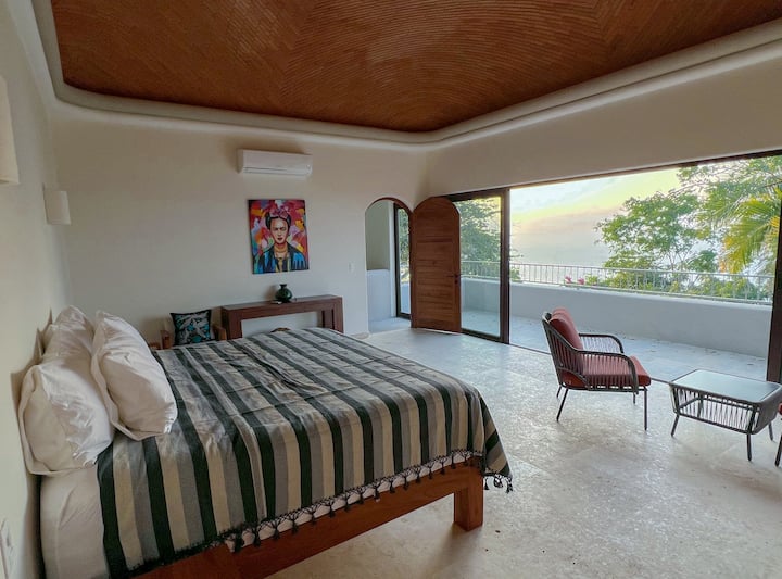 ห้องนอนใหญ่พร้อมเตียงคิงไซส์เพดานโบเวดาและวิวทะเล