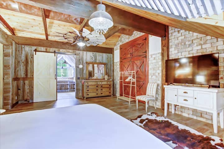 El dormitorio privado tamaño king tiene TV inteligente privada y acceso a baño completo con ducha a ras de suelo.