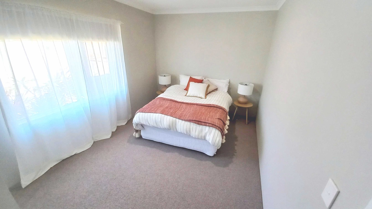 Dormitorio rojo; el baño privado está fuera de las fotos detrás de la cámara.