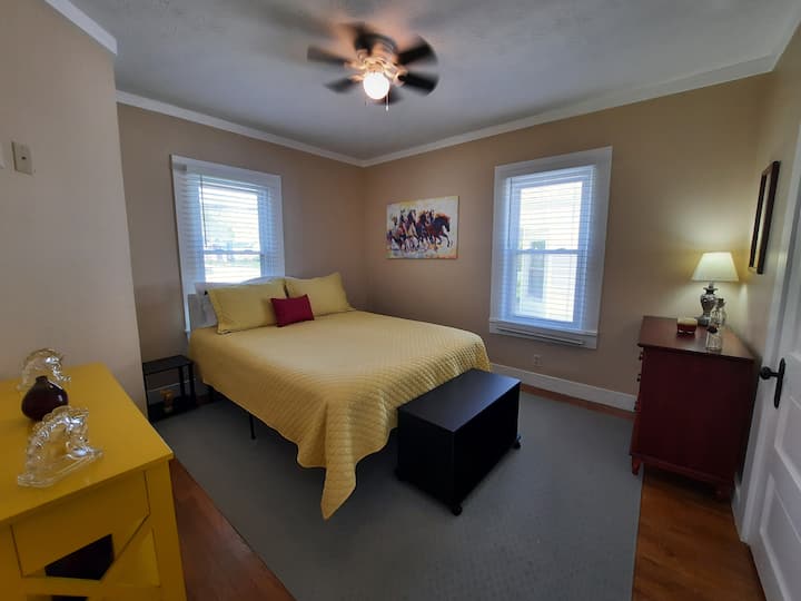 Guest bedroom off of the living room with queen bed.