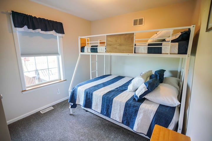 The second bedroom can sleep up to 4. The top bunk is a twin, and the lower bed is a full-size mattress. A twin-sized trundle bed can also be pulled out from below. The room includes a small closet. The window looks out over the hills.