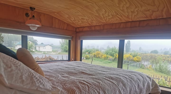Queen bed with views over river.