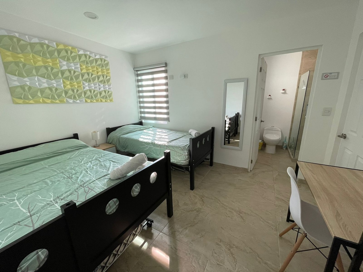 Gezellige ruimte voor drie personen, met eigen complete badkamer. Je hebt ruimte om je spullen op te bergen en een bureau om te werken.