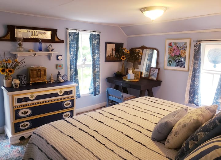 Onze blauw-witte kamer, met een kingsize bed en een bureau voor werk.