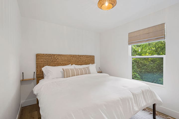 Downstairs bedroom with king bed made with cozy linen-blend sheets, USB and USB-C bedside outlets and room-darkening shades.