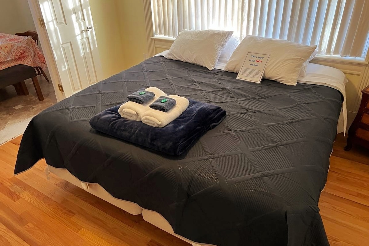 เตียงขนาดคิงไซส์บนชั้นหลักมีโต๊ะด้านหนึ่งโคมไฟตั้งโต๊ะปลั๊ก USB ชั้นวางของเก้าอี้ทีวีและตู้เสื้อผ้าพร้อมไม้แขวนเสื้อ