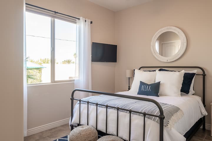 Queen bed with a view of the pool and lake.