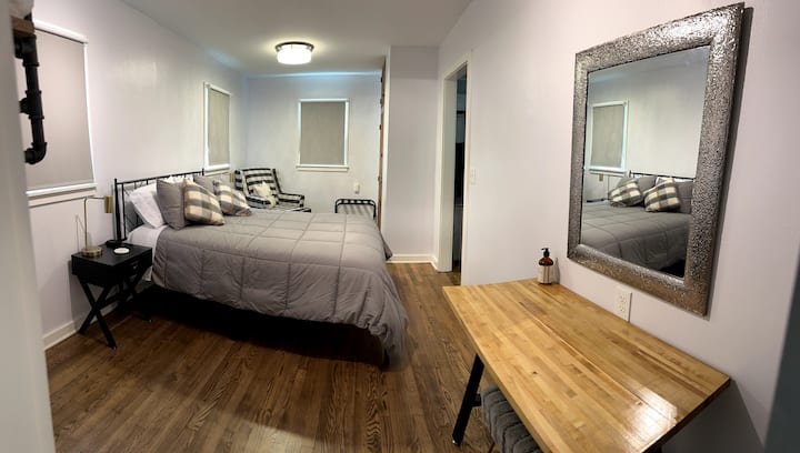 Large bedroom with queen bed, vanity and sitting area