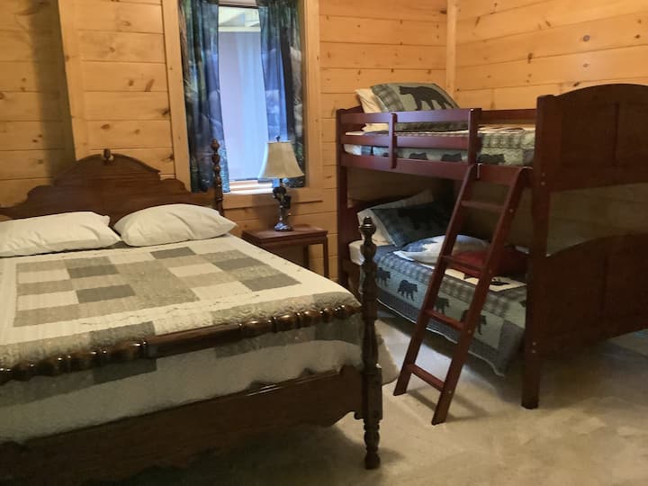 Escape the bustling vacation crowd and find tranquility in this cozy kids' bedroom, complete with a bunk bed and full-sized bed, offering a peaceful haven for much-needed rest and rejuvenation.