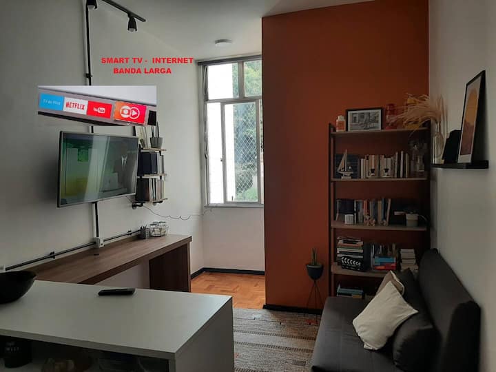 غرفة معيشة بتلفزيون ذكي ومكتب وسرير أريكة