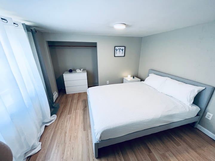 غرفة نوم مشرقة لطيفة مع نافذة كبيرة وسرير بحجم كبير وأدراج . حامل إضاءة LED الليلي مع بلوتوث وتغيير لون حسي اللمس. 