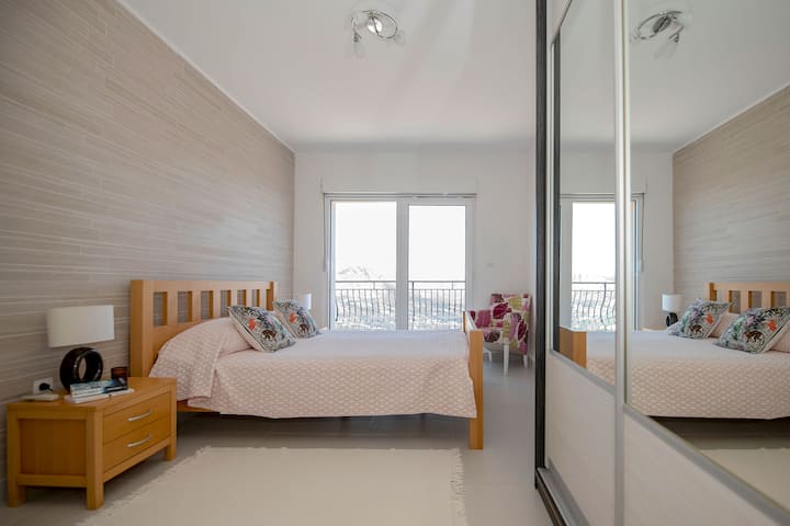 GLAVNA SPAVAĆA SOBA S IZLAZOM NA BALKON S POGLEDOM NA MORE, ORMAROM, KLIMA-UREĐAJEM I VLASTITOM KUPAONICOM.