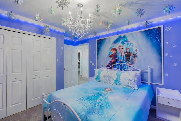 Ingia kwenye mapumziko ya Enchanted Frozen: vitanda viwili vilivyopambwa katika duvets za Elsa & Anna, decals za theluji, chandelier kung 'aa juu, KUONGOZWA na trim kung' aa kando ya kuta za bluu za anga, na ukuta wa kifahari wa Arendelle- mahali ambapo kila usiku huangaza maajabu.         