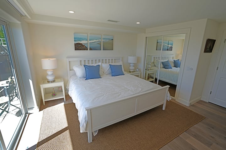 سرير بمقاس كبير في الطابق الأول مع إمكانية الوصول المباشر إلى الفناء والشاطئ.