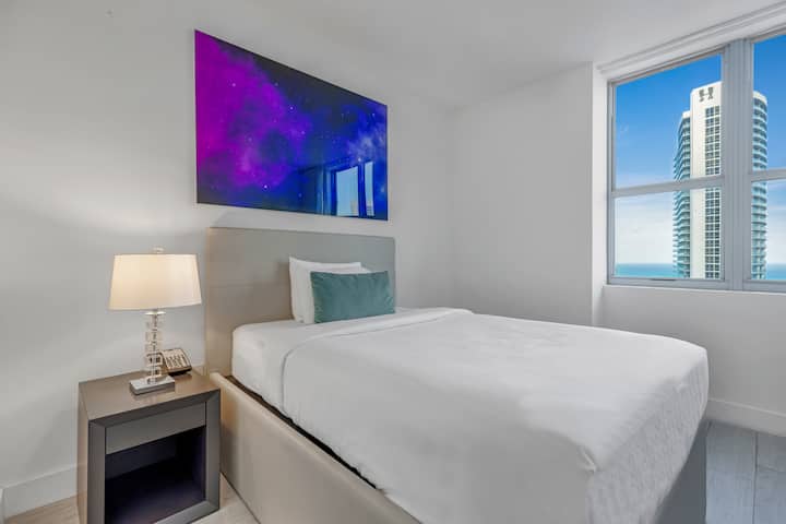 Entra en el segundo dormitorio, diseñado para la comodidad con una cama doble y un colchón de suelo adicional. Un espacio de trabajo elegante facilita la productividad, mientras que un baño designado justo al lado añade comodidad.