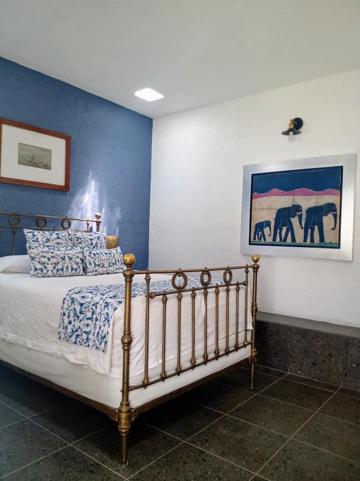 חדר שינה כחול עם חדר רחצה ושולחן כתיבה 