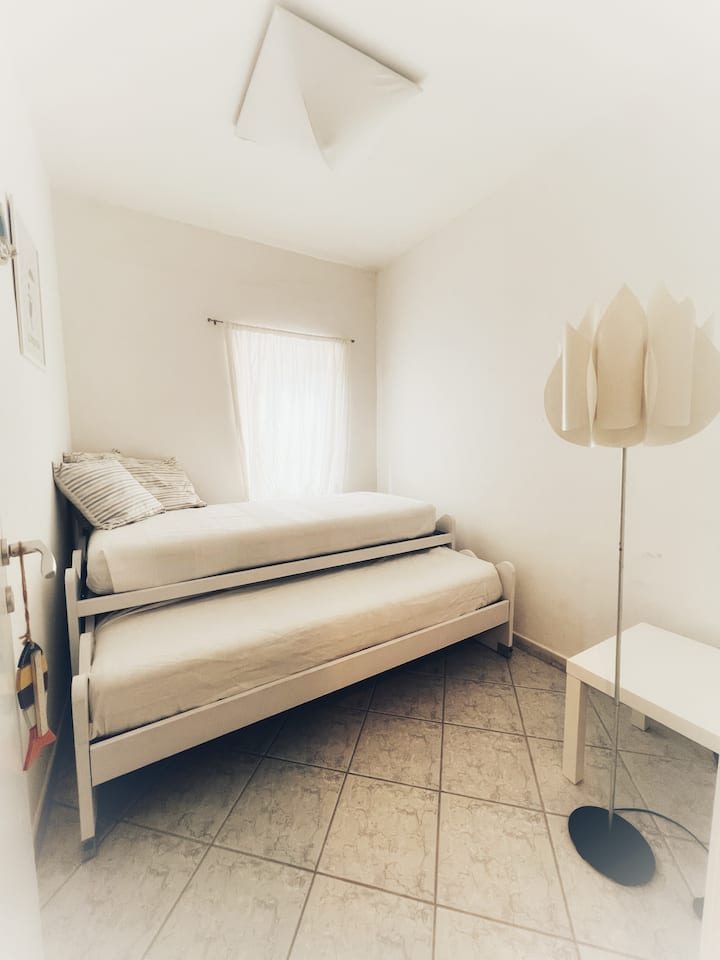 Dormitorio con dos camas individuales en la estructura principal