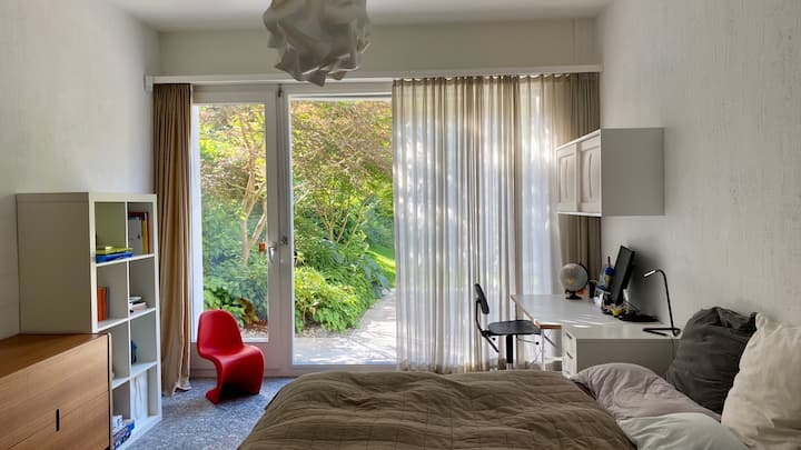 Slaapkamer met tweepersoonsbed en directe toegang tot de tuin