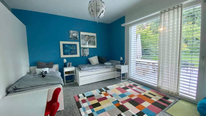 Slaapkamer met eenpersoonsbedden en directe toegang tot de tuin