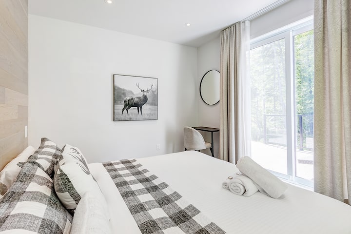 Cozy king bedroom with workspace and outdoor view.