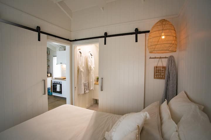 الصفاء والراحة: غرفة نوم رئيسية مريحة بسرير كبير ومروحة سقف وإضاءة الأجواء.