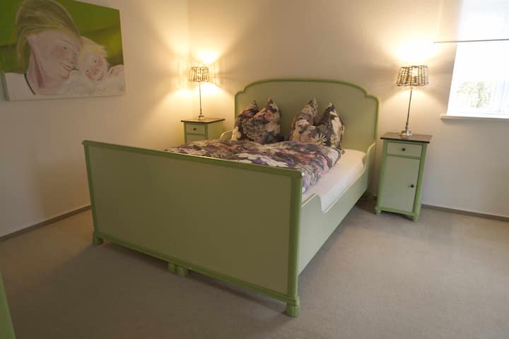 Ein Doppelbett im geräumigen "grünen Zimmer".