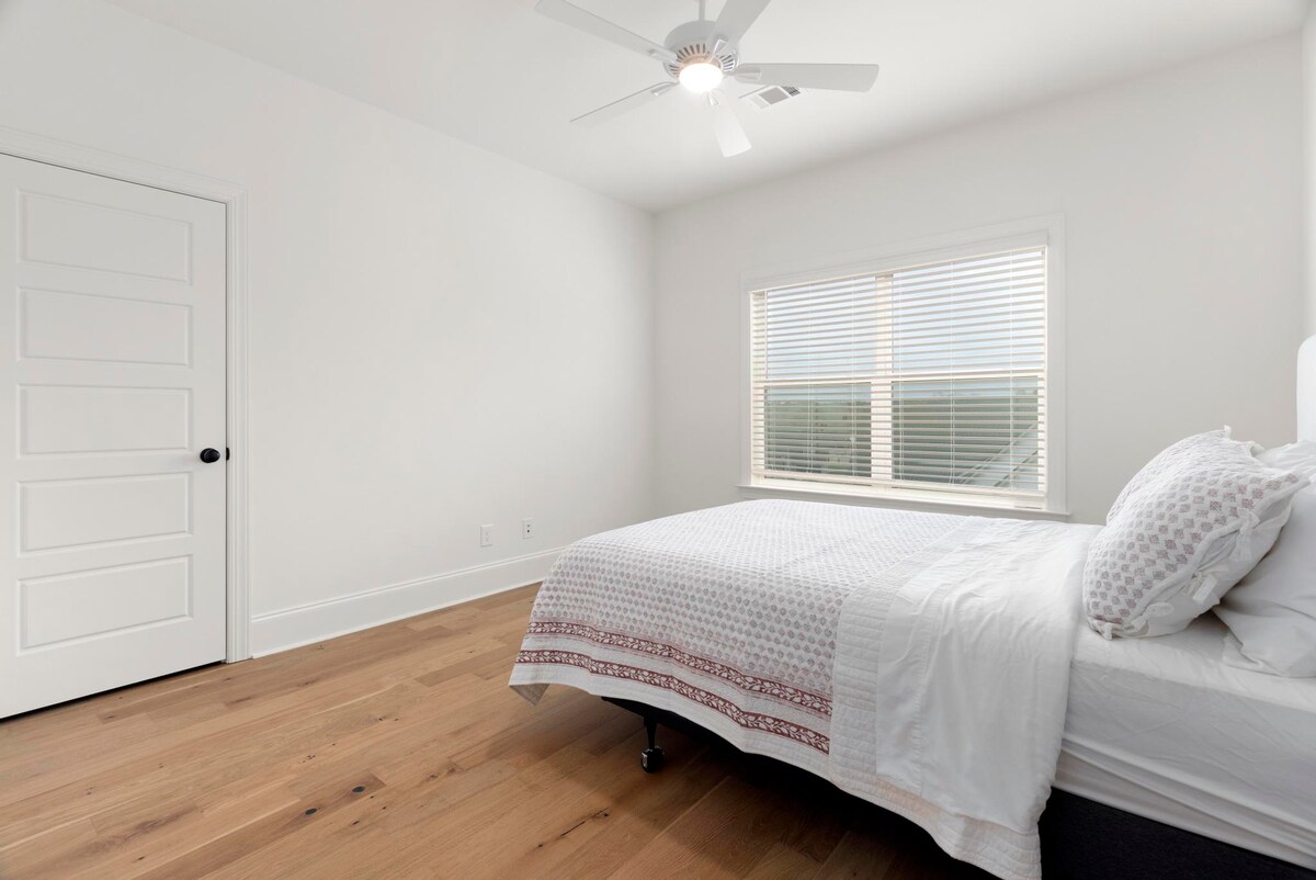 Chumba kingine cha kulala cha malkia kilicho kwenye ghorofa ya juu kikiangalia ua wa nyuma.
