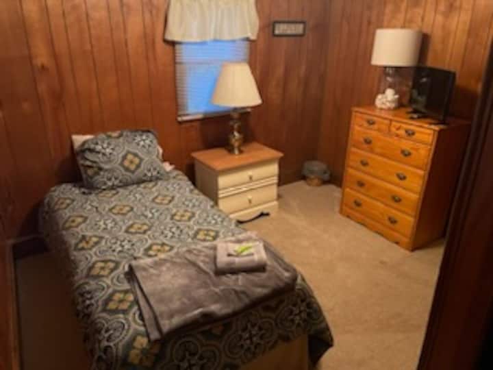 Chumba cha kulala cha ghorofani chenye kitanda kimoja.  Kumbuka Smart TV kwenye kabati la nguo.