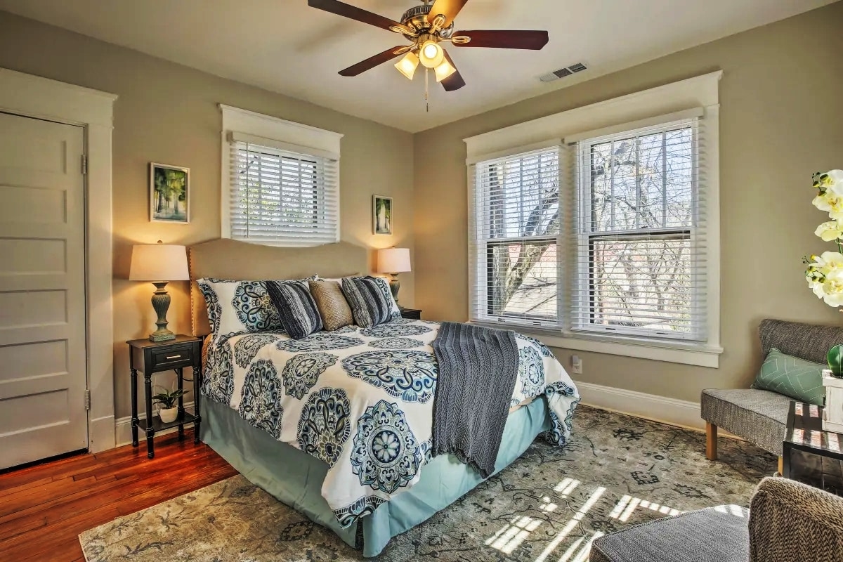 This Queen-sized spacious room has a sitting area, 55 inch mounted TV and a laundry basket and storage unit in the closet. The art decor highlights the warmth and sophistication of the room..