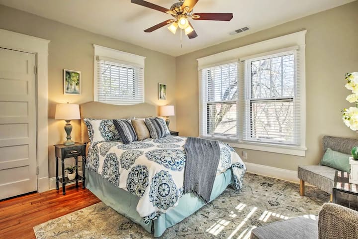 Cette chambre spacieuse de taille Queen dispose d'un coin salon, d'une télévision de 55 pouces, d'un panier à linge et d'une unité de rangement dans le placard. La décoration artistique met en valeur la chaleur et la sophistication de la chambre.