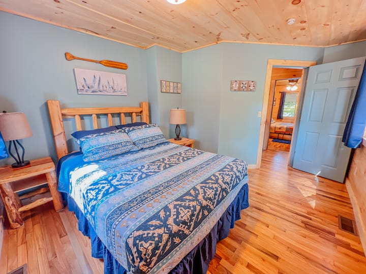 Chumba kikuu cha kulala cha ghorofa 1 kiko mbele ya nyumba ya mbao.