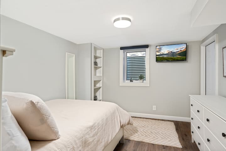 Спалня на по - ниско ниво, пълно легло, 32 - инчов TCL телевизор