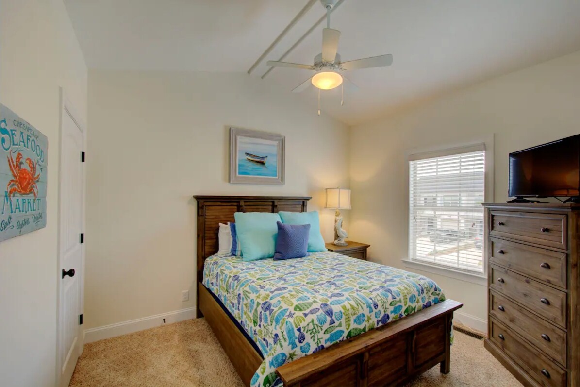 Tranquilo dormitorio tamaño queen temático de playa.