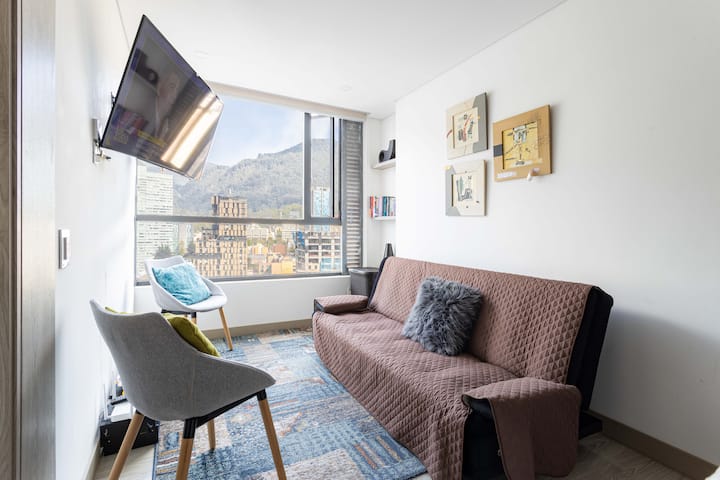 غرفة معيشة ذات إطلالة جميلة وأريكة مريحة وتلفزيون ذكي