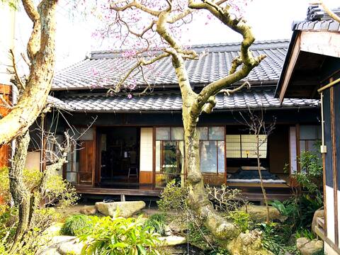 Uma casa inteira de 95 anos cercada por uma piscina e um jardim japonês.