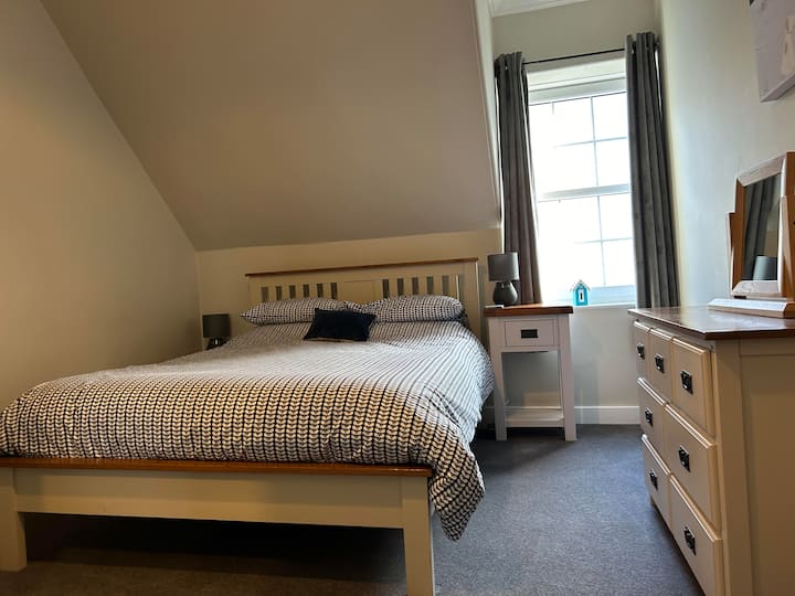 غرفة نوم مزدوجة في أتيك بورتباتريك. غرفة مزدوجة ذات حجم جيد وسرير بمقاس كبير مع خزانات ومصابيح متطابقة بجانب السرير وصندوق أدراج وخزانة ملابس. يتوفر مجفف شعر قوي. 