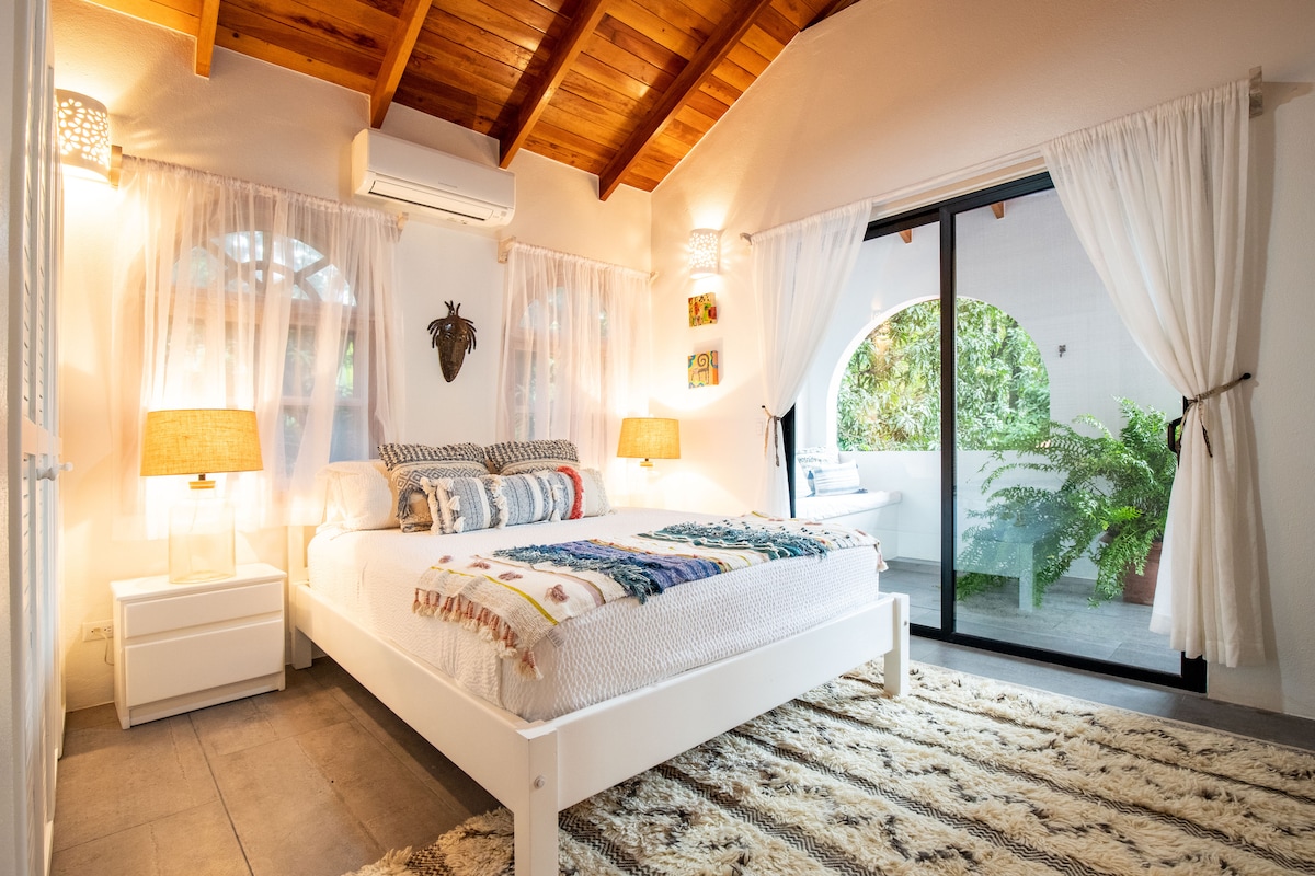 غرفة نوم صغيرة مجددة حديثًا مع حمام داخلي وشرفة