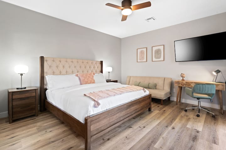 Spacious bedroom with a king size bed and a large TV.