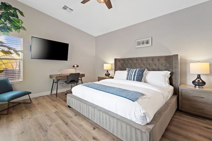 Primary bedroom with a king-size bed and a TV.