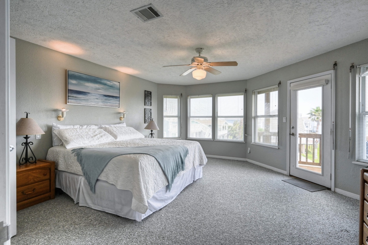 Amplia suite principal con ventanas circundantes y entrada en balcón privado con vistas al mar