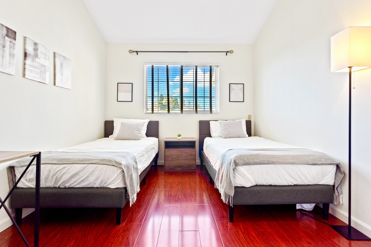 Camas individuales con arte de pared abstracto y escritorio de trabajo de 40 pulgadas. ¡Ideal para niños y amigos! Mucha luz natural