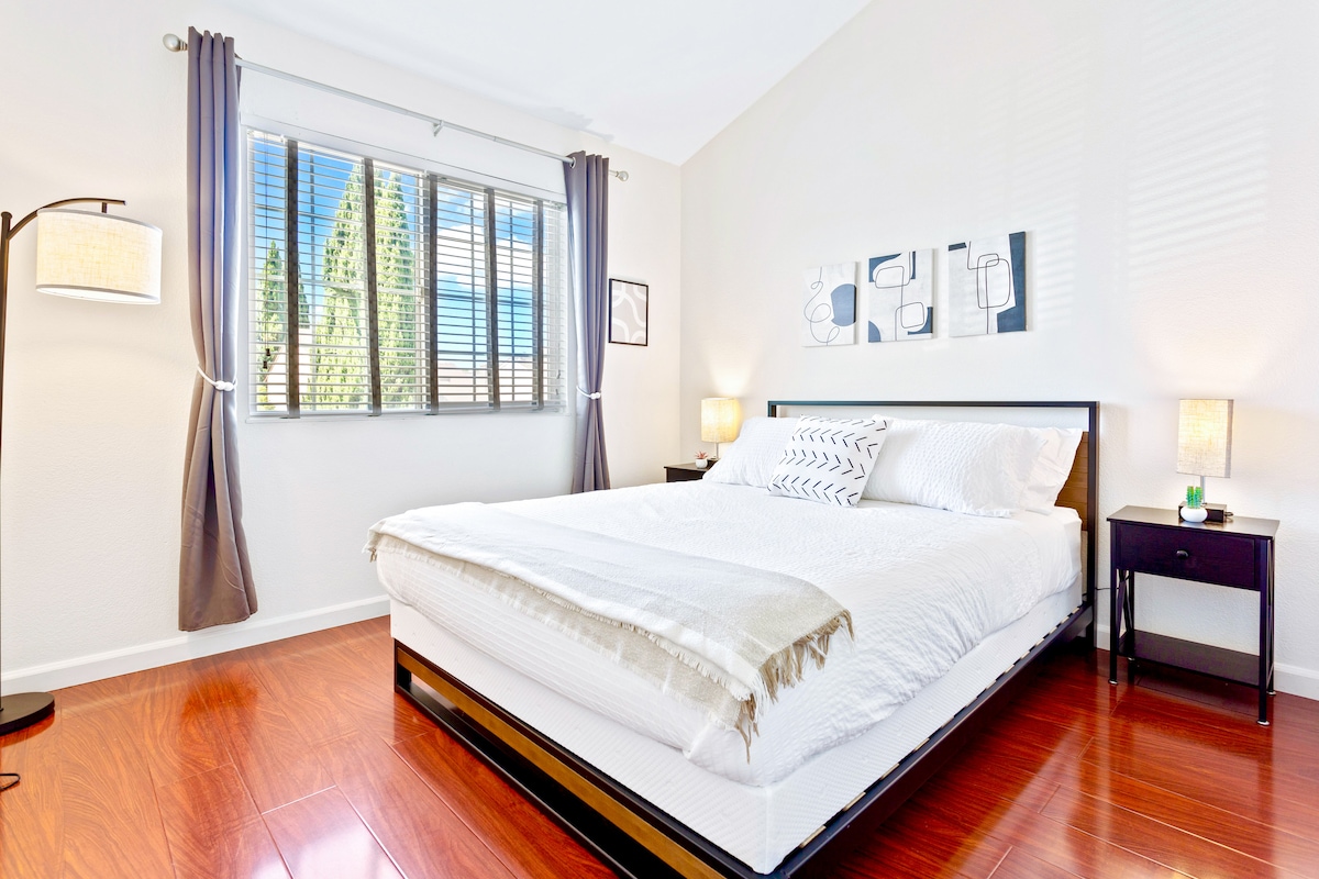 Cama tamaño queen con arte moderno, mucha luz natural y cortinas opacas, tiene un escritorio plegable de 30 pulgadas en el armario.