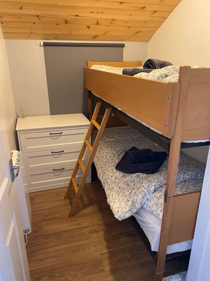 Celoplošná poschodová posteľ, zásuvky a šatník.