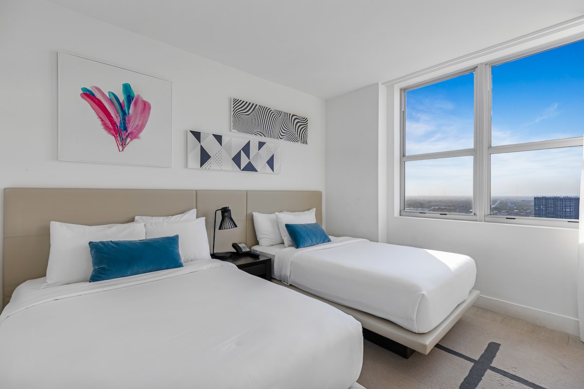 ก้าวเข้าสู่ห้องนอนแรกที่มีเตียงคู่สบายๆ 2 เตียง เหมาะสำหรับครอบครัวหรือกลุ่มเพื่อน สว่างและโปร่งโล่งด้วยแสงธรรมชาติและการตกแต่งที่ทันสมัย มีพื้นที่ผ่อนคลายสำหรับการพักผ่อนยามค่ำคืน