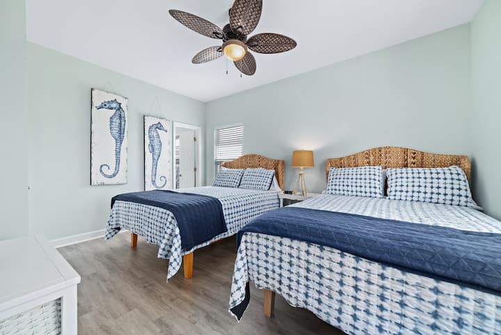 Airy beachy retreat with balcony views and 2 cozy queen beds.