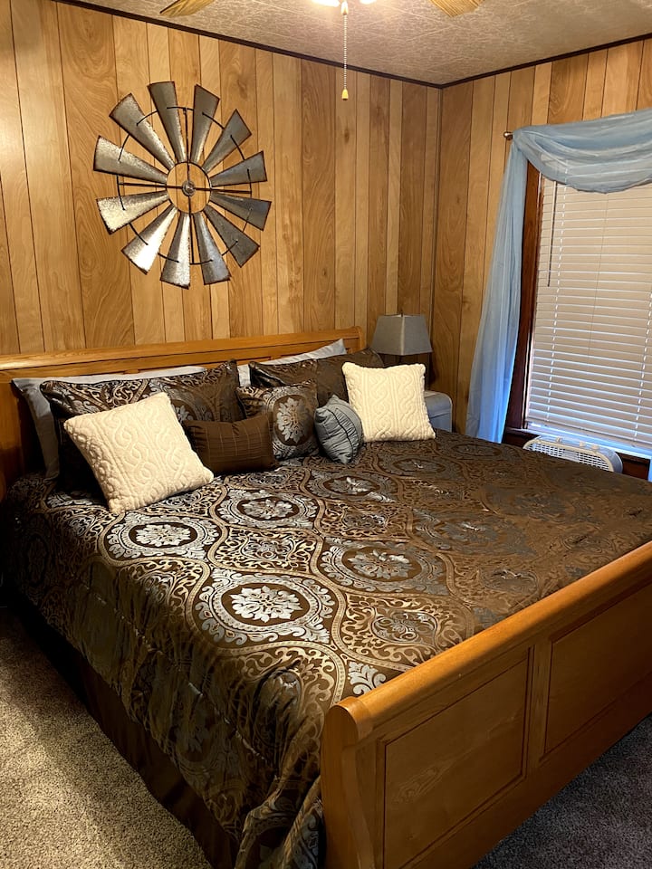 Kingslaapkamer met sleebed, antiek dressoir en vintage quilt.