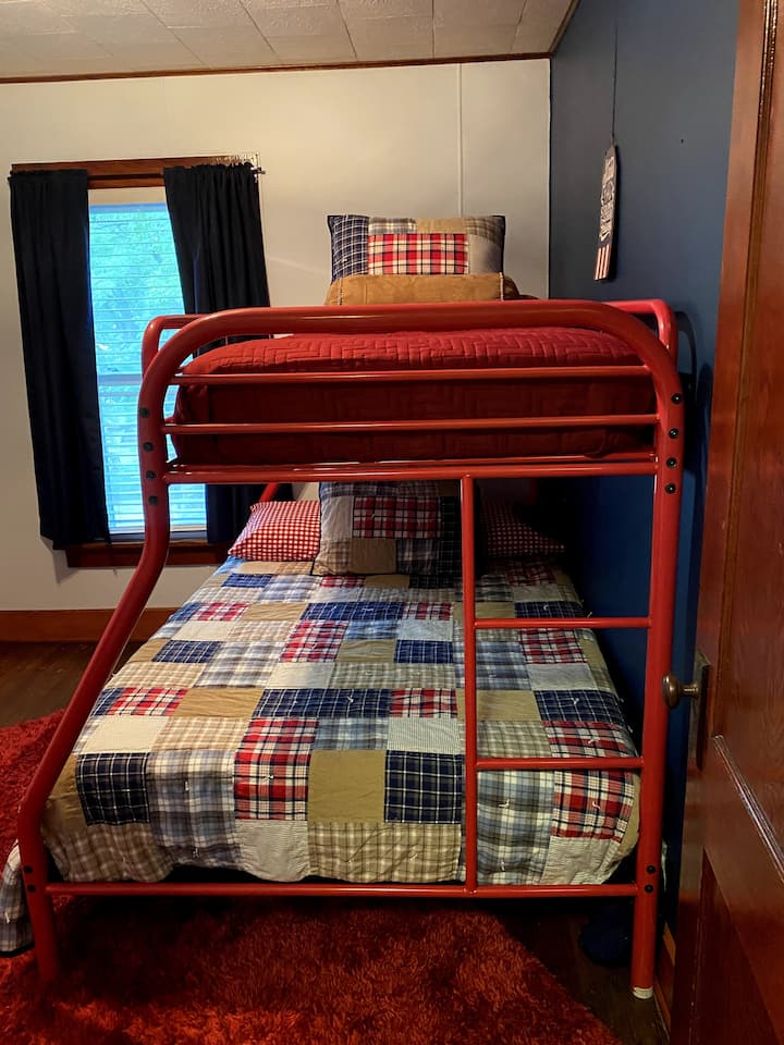 Stapelbedkamer met twee eenpersoonsbedden boven volledige bedden.  Instellen voor een kind, maar kan gemakkelijk worden gebruikt door een volwassene.